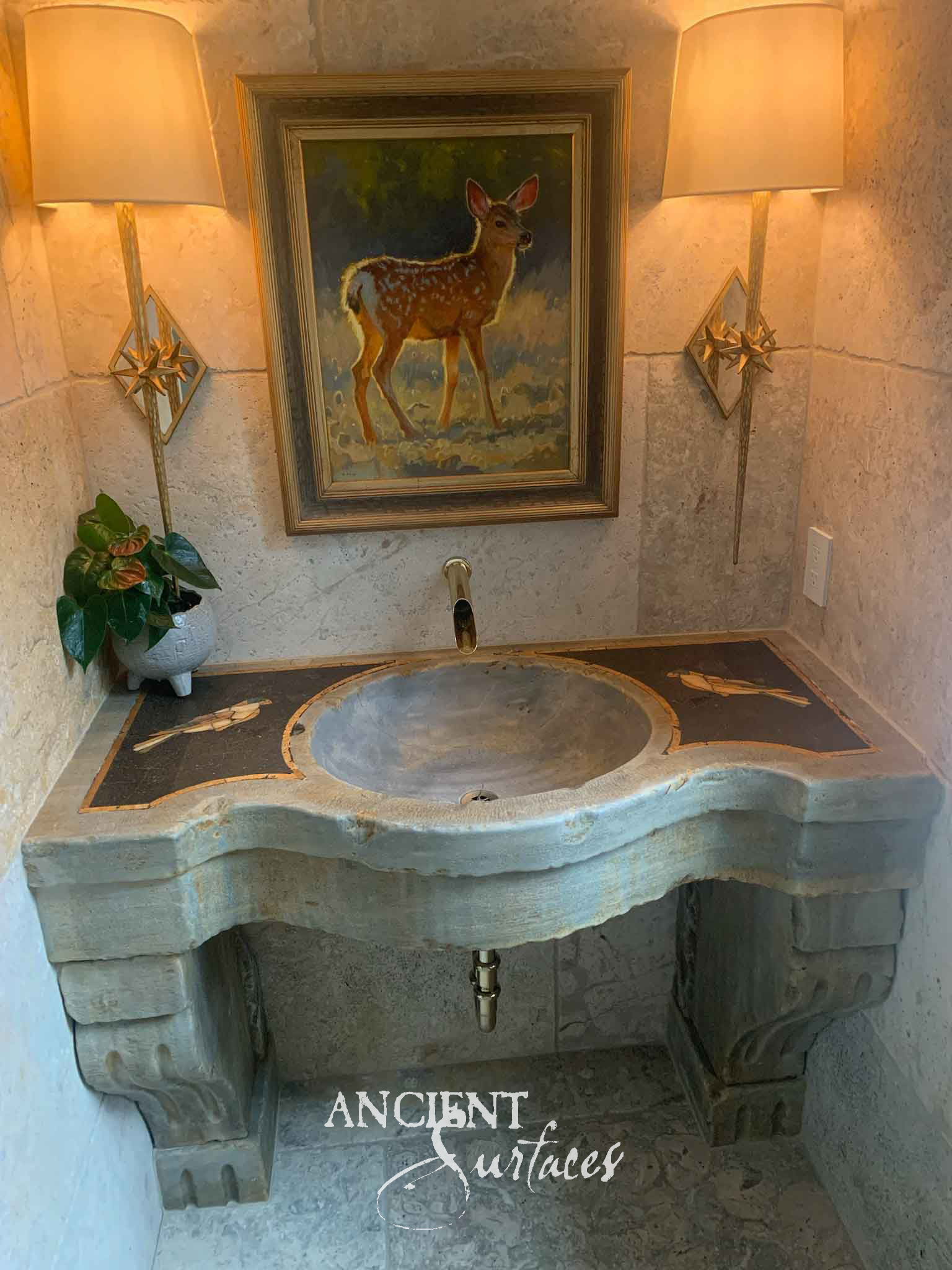 Antique reclaimed limestone sink with a round basin and bird-motif marble inlay installed beneath a framed painting