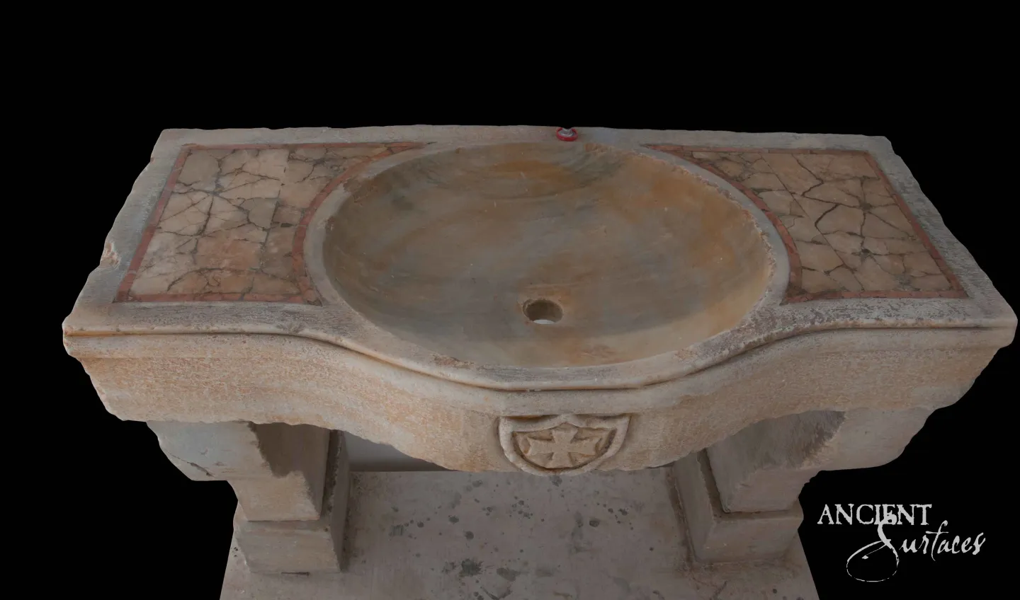 Reclaimed limestone sink with an oval basin, red-and-tan mosaic panels and a carved cross medallion