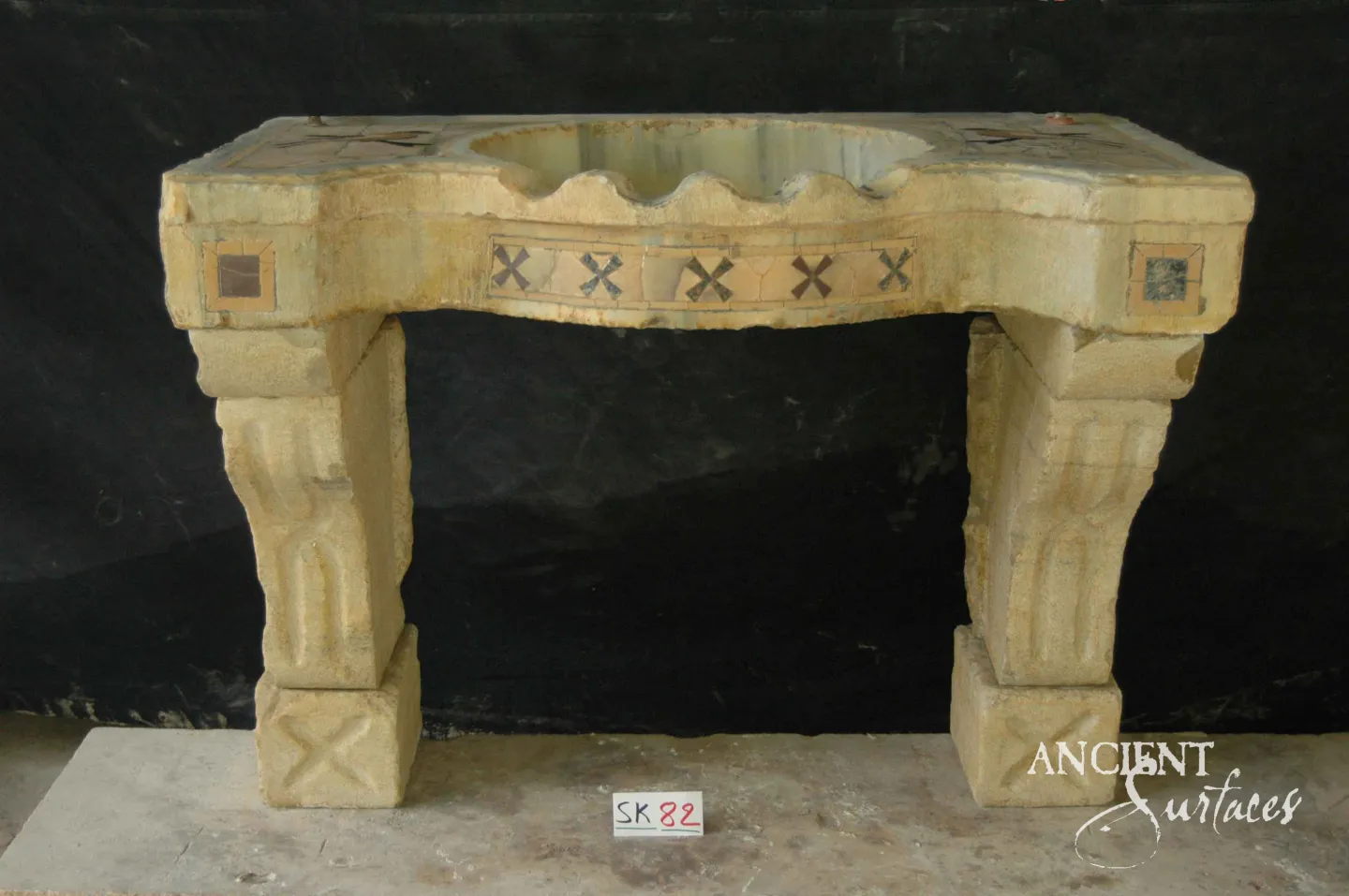 Reclaimed limestone sink with an X-motif mosaic apron band on two carved corbel legs