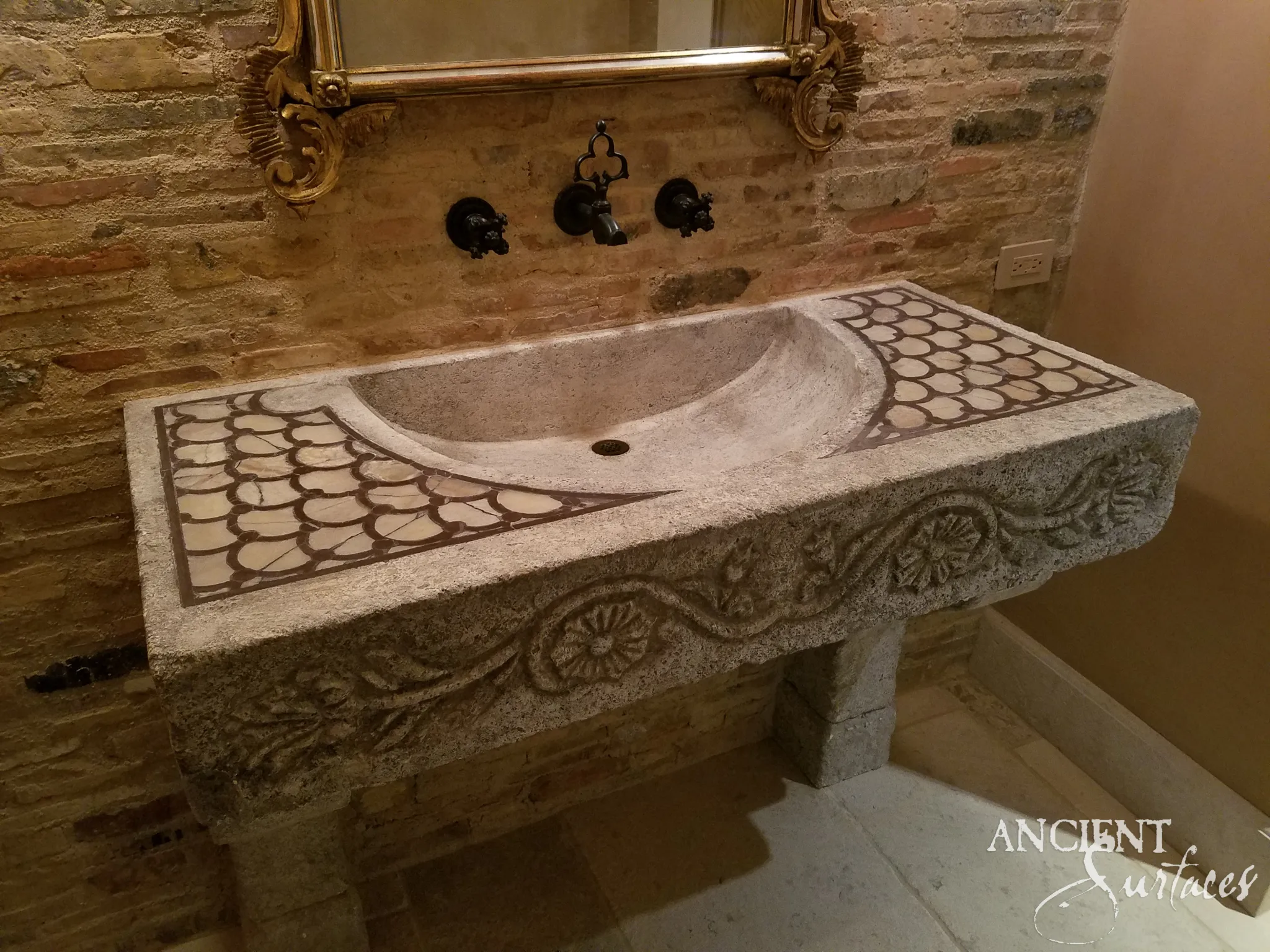 Reclaimed limestone sink with fish-scale mosaic corners and a carved rosette-and-vine front apron