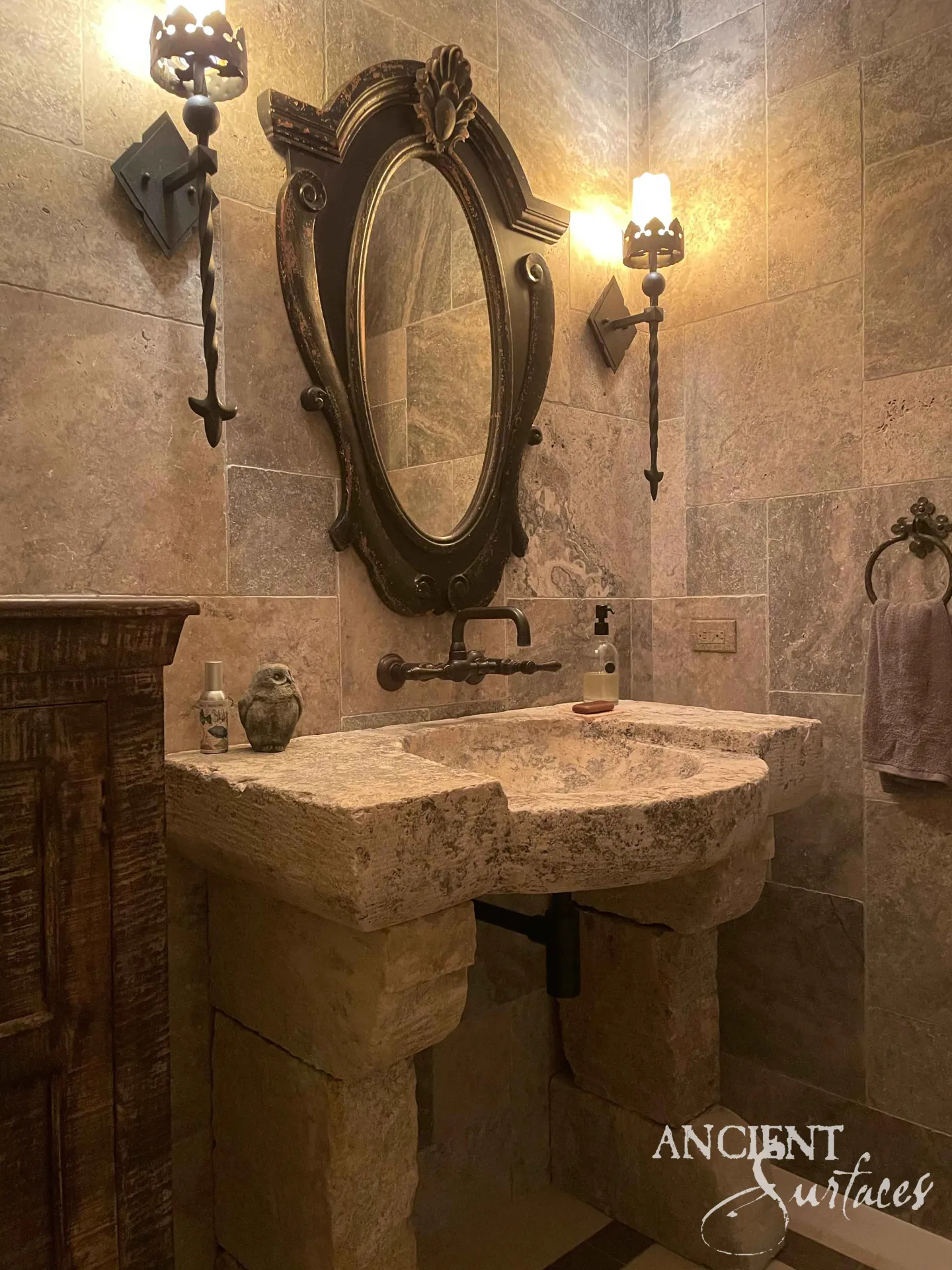 Rustic freeform reclaimed limestone basin carved from a rough block on two reclaimed-stone pillars